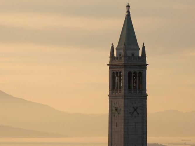 The Campanile is seen from the Berkeley hills east of the campus at sunset.