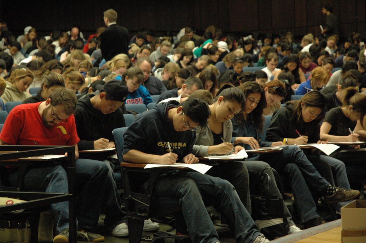 Large classroom of students taking an exam.